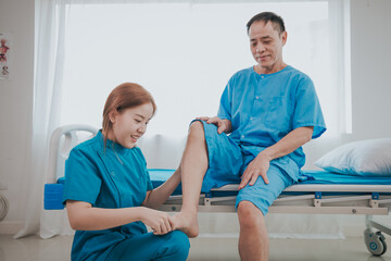 Asian female physiotherapist helping senior older woman stretching hamstring, Rehabilitation...