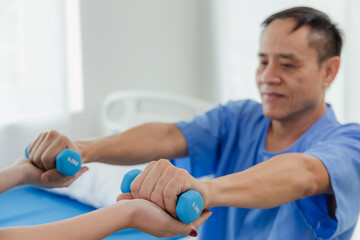 Obraz premium Physical therapy assistance Asian female doctor with senior man in physical therapy rehabilitation or health support Female physical therapist or physical therapist counseling an elderly patient.