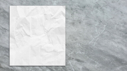 close up of white grunge paper placed on grey emperador marble stone table with blank space for design. empty white paper sheet on beautiful stone table in top view.