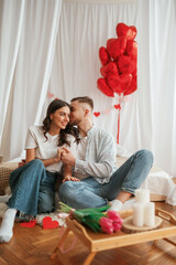 Bunch of heart shaped balloons, celebrating. Young couple are together at home