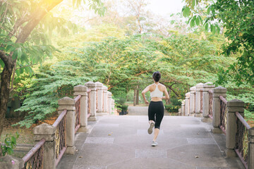 Fototapeta na wymiar asian woman jogger, running over the bridge in public park.