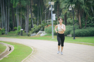 asian woman jogger running in green nature public park. - 788388279