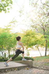 Female jogger. Fit young Asian woman with sportswear stretching muscle in park before running and enjoying healthy outdoor. Fitness runner girl in public park. Wellness being concept