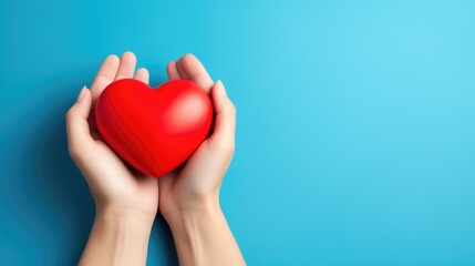 Obraz premium Heartwarming Moment: Hands Holding Red Heart on Blue