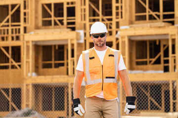 roofer builder working on roog structure of building on construction site. handsome young male...