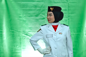 Close up photo young girl Indonesian National Flag Hoisting Troop looking to the copy space. National Paskibraka Council isolated in green background
