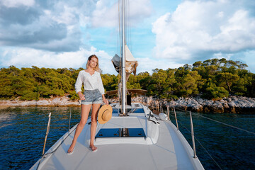 Luxury travel on the yacht. Young happy woman on boat deck sailing the sea. Yachting in sea.