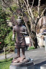 Buddhist Hase-kannon temple upper main square statue man with lion in Kamakura, Japan in March