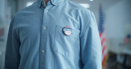 Close up of anonymous businessman or man putting on badge with American flag logo and inscription I Voted. US citizen at polling station during elections. National Election Day in the United States.