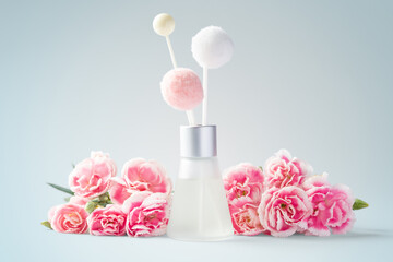Obraz na płótnie Canvas Fragrance diffuser and pink flowers on vintage blue background