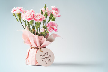Pink flower bouquet with mothers day card on vintage blue background