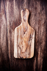 Cutting board on rustic wooden background. Top view. Close up. Copy space.
