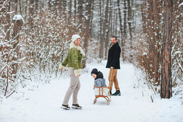 Fototapeta na wymiar Happy family walking in winter forest