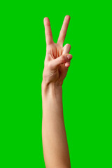 Hand Making Peace Sign Gesture Against Vibrant Green Background