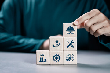 HSE, Health safety environment concept. Standard safe industrial work and industrial. Person stacking wooden block with HSE icon for business and organization.
