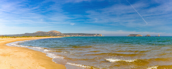 Panorámica de la Playa de la Estartit en la Costa Brava, con vistas a las montañas y las Islas Medas, en una clara tarde de primavera. - obrazy, fototapety, plakaty