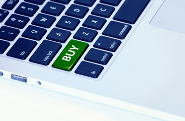 Closeup of a laptop keyboard with a green buy button