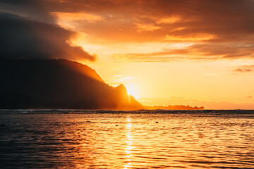 Naklejka na ściany i meble sunset over the ocean with hawaii mountains