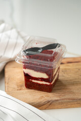 Trifle red velvet in plastic cup on table