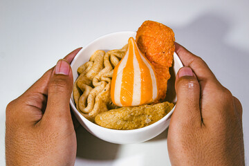 traditional Japanese food, odeng, served in a porcelain bowl and held in two hands