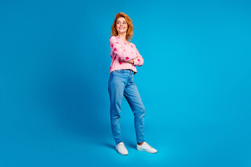 Full length photo of lovely young lady crossed hands look empty space dressed stylish pink clothes isolated on blue color background
