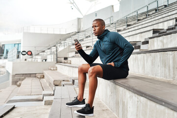 Fitness, phone and man thinking on stadium steps for training break, pause or social media scroll....
