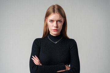 Young Woman Wearing Black Top and Jeans against gray background