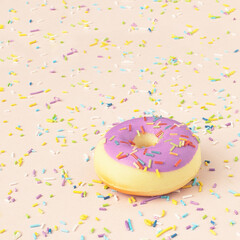 Trendy pattern of colorful sprinkles with donuts on bright background. Concept for decoration cake and bake