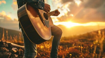 Guitarist man stands on grassland meadows field playing guitar during sunset