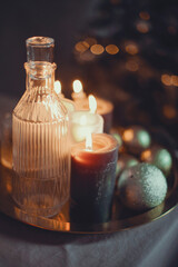 New Year's still life. Glasses and a decanter from transparent glass, candles and golden xmas ball