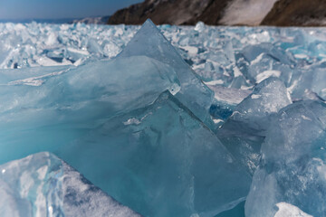Pieces of ice lying on the ideal smooth ice of baikal with ice hummocks in the horizon