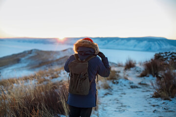 Young man standing in winter frozen nature. Ogoy island, lake Baikal, Siberia, Russia