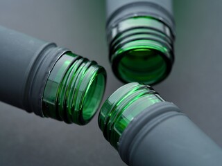 A close-up shot of three open neck of wine bottles on a black background