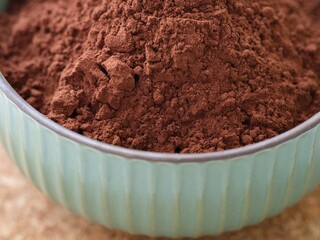 Organic cocoa powder in a turquoise bowl. Close-up