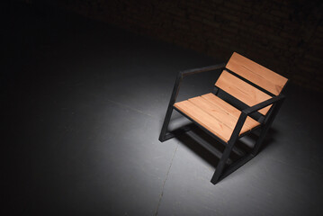 Iron loft style armchair on the black dark background. Front view.