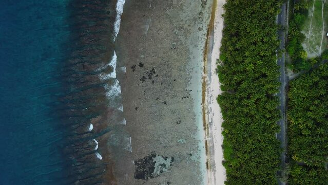 Tropical coastline with ocean, tropical beach and road in Fuvahmulah. Aerial view