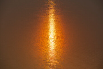 Sunlight reflected on the water surface.Dramatic golden sunset tropical sea background.Yellow sun...