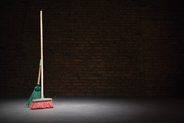 Broom and dust pan on the dirty dusty floor. Cleaning concept.