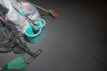 Broom, dust pan , bucket, mop, vacuum cleaner and trash bags garbage on the dirty dusty floor....