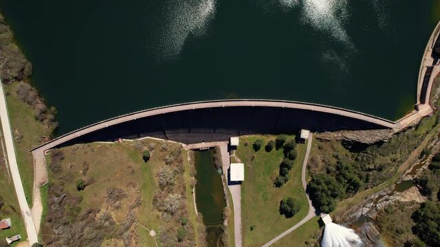 Aerial view of a scenic mountain reservoir lake and a Dam for hydroelectric power generation. High quality 4k footage