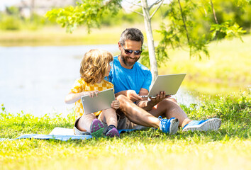 father and son have online education outdoor. Pupil with teacher studying online and work on tablet in park. dad and kid son study. childhood education of son with father. Outdoor distance learning