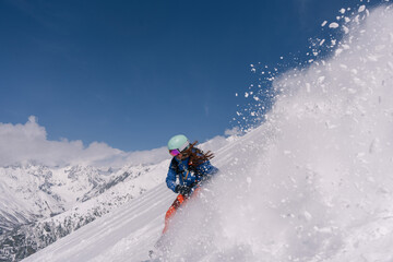 Woman snowboarder riding on slope of powdery snow in high mountains. Freeride at ski resort, Snow...