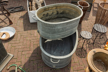 two zinc tubs are stacked on top of each other outside on the street - obrazy, fototapety, plakaty