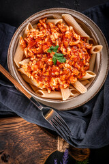 Penne pasta with minced chicken meat in tomato sauce.