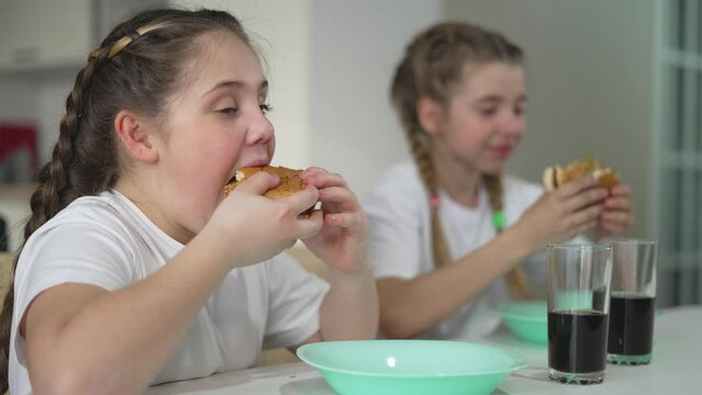 kids sit and celebrate weekend with hamburger feas enjoying every bite. weekend is marked by children laughter and shared burgers. Burgers and weekend mood children enjoy every pleasant moment.