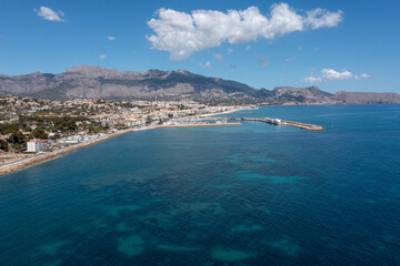 Aerial drone photo of the Spanish town of L'Albir in Spain Alicante showing the beach front on a sunny summers day with the Spanish mountains in the background