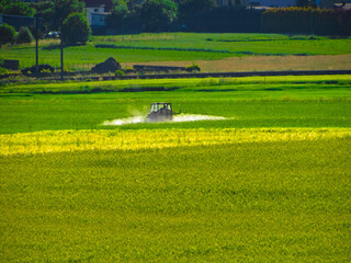 Farmer spraying farmland on a tractor