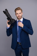 Business photographer with camera. Journalist man taking photo isolated on grey. Paparazzi photographer. Businessman hold photo camera. Press photographer. Photojournalist in business suit - 788514459