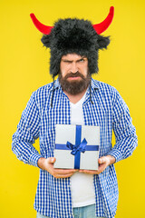 Man with gift isolated on yellow. Birthday gift. Party on mens day. Mens day. Halloween party present. Man on February 14. Bearded guy hold present box for Valentines day. Happy Halloween. Angry guy - 788518061
