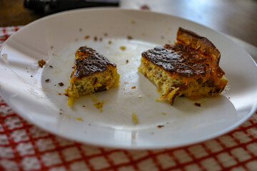 sliced savoury quiche pie on rustic checkered cloth